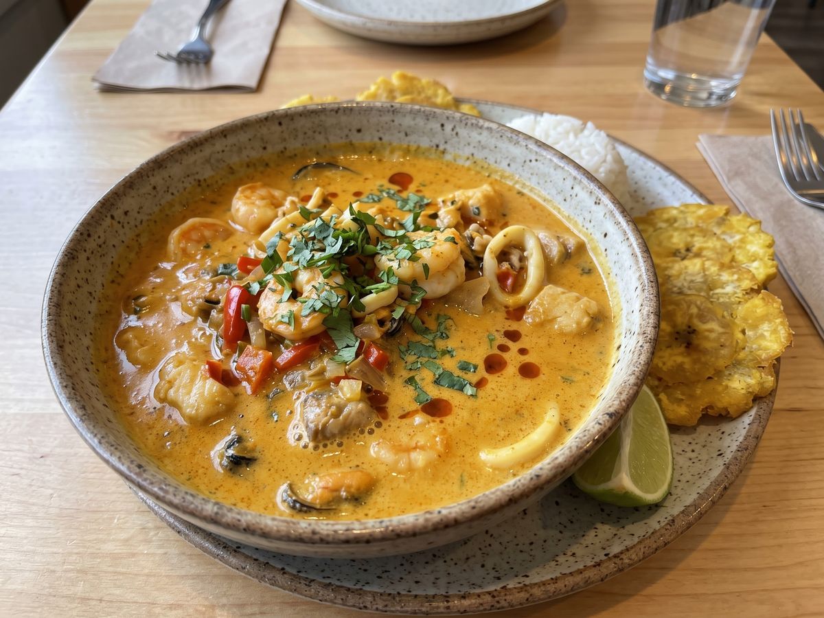 Encocado de mariscos in coconut sauce with rice and patacones